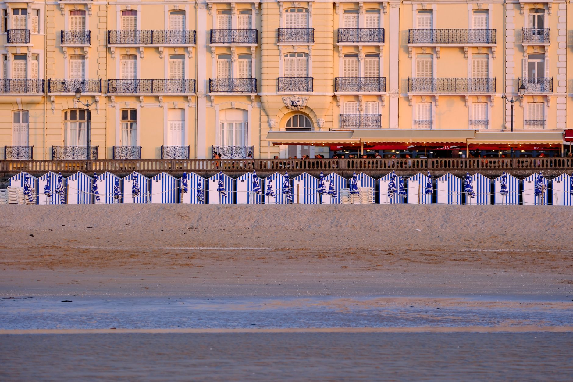 Beachfront hotel with striped cabanas in Cabourg, Normandie, France. — photograph by Lewis Bedar on Pexels