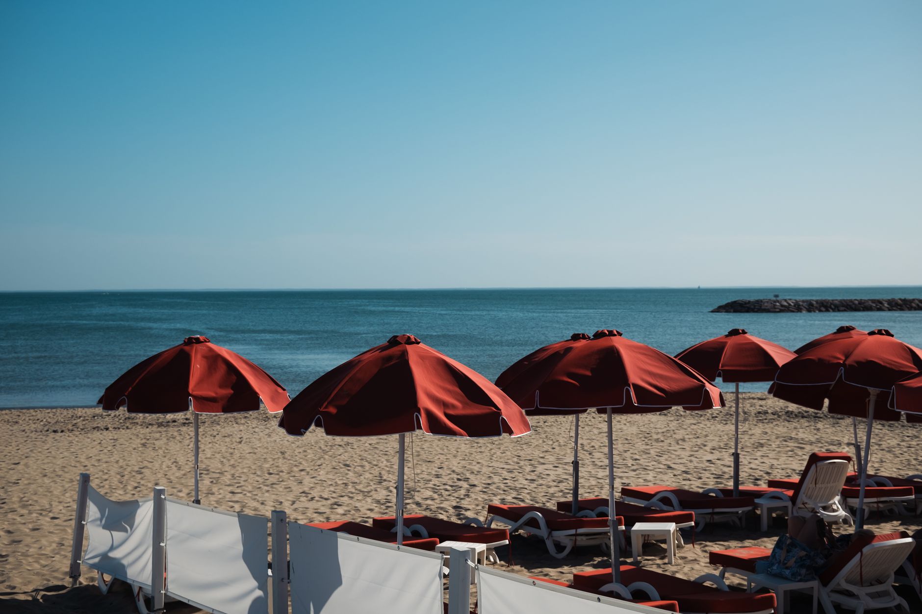 Scenic view of red parasols on La Grande-Motte beach, France, with the Mediterranean Sea. — photograph by Tom Macret on Pexels