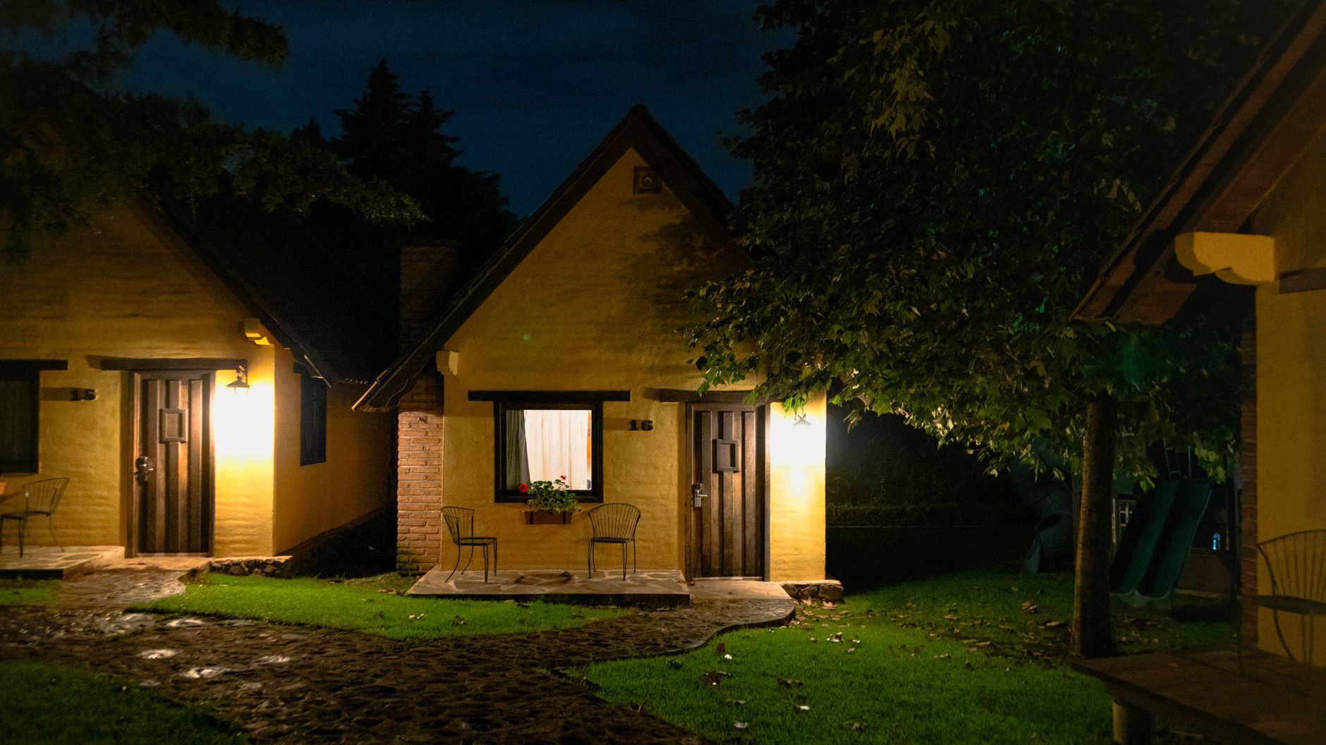 Charming yellow cottages glow warmly under twilight, offering a tranquil, scenic retreat. — photograph by Ángel Fernández on Pexels