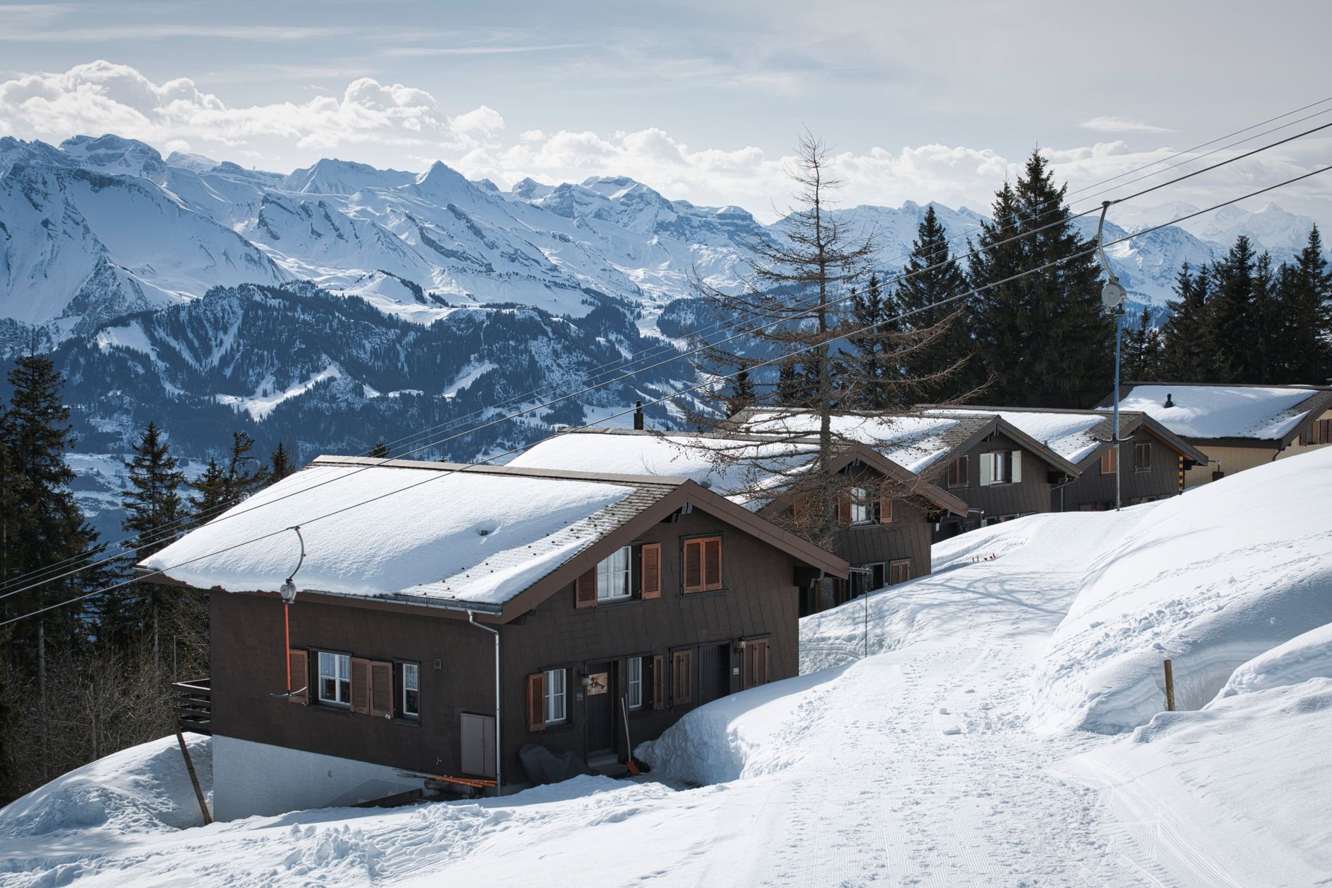 Idyllic snowy chalets nestled in the stunning Alpine mountains with a serene winter view. — photograph by Sergio Zhukov on Pexels